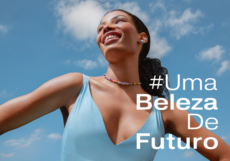Foto tirada debaixo para cima de mulher negra com uma regata azul e sorrindo. Atrás dela está o céu. Legenda da imagem é #UmaBelezaDeFuturo